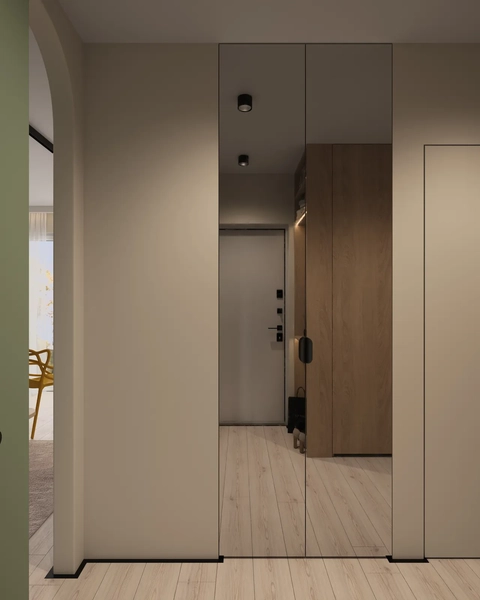 A hallway with a mirrored closet door, wooden storage unit, and a light-colored wooden floor.