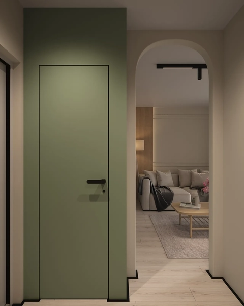 A green door set in a wall, leading into a softly lit room with a beige and cream color palette, featuring a living area with a sofa and coffee table visible in the background.