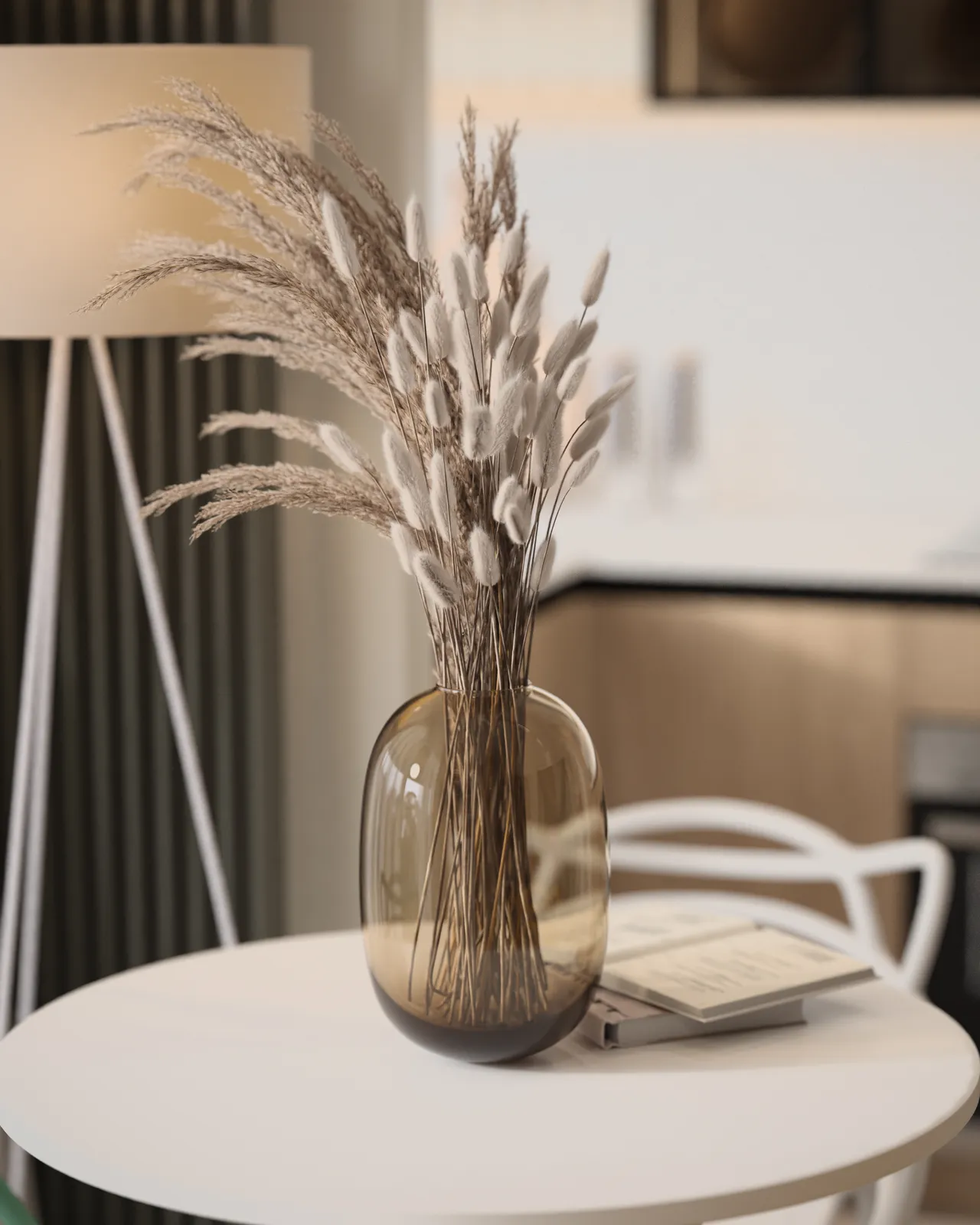A decorative vase filled with dried flowers, placed on a white table in an interior setting.