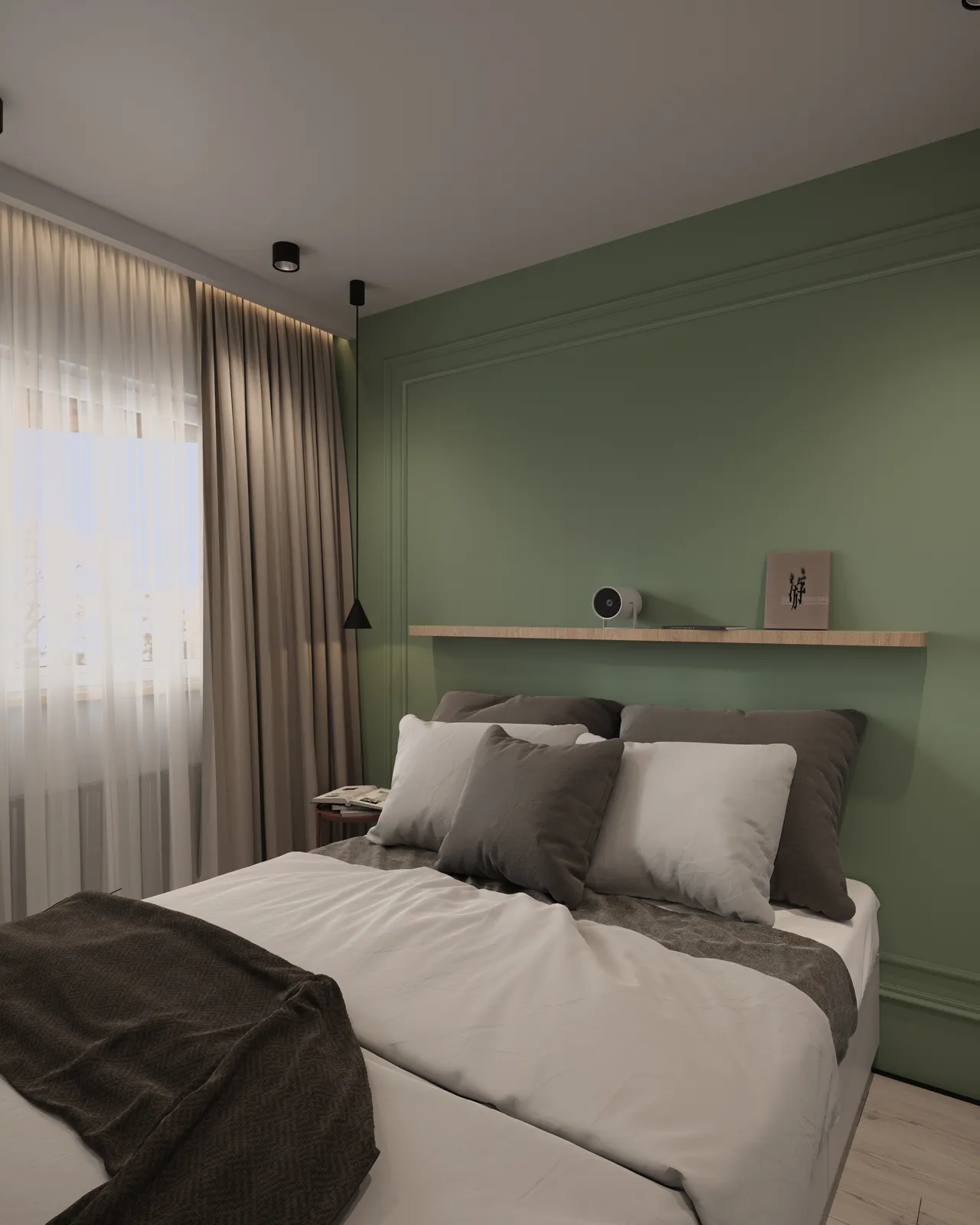 A cozy bedroom featuring a bed with white and gray pillows, a throw blanket, and soft lighting. The walls are painted green, and there is a window covered with sheer curtains. A shelf is mounted above the bed with decorative items.