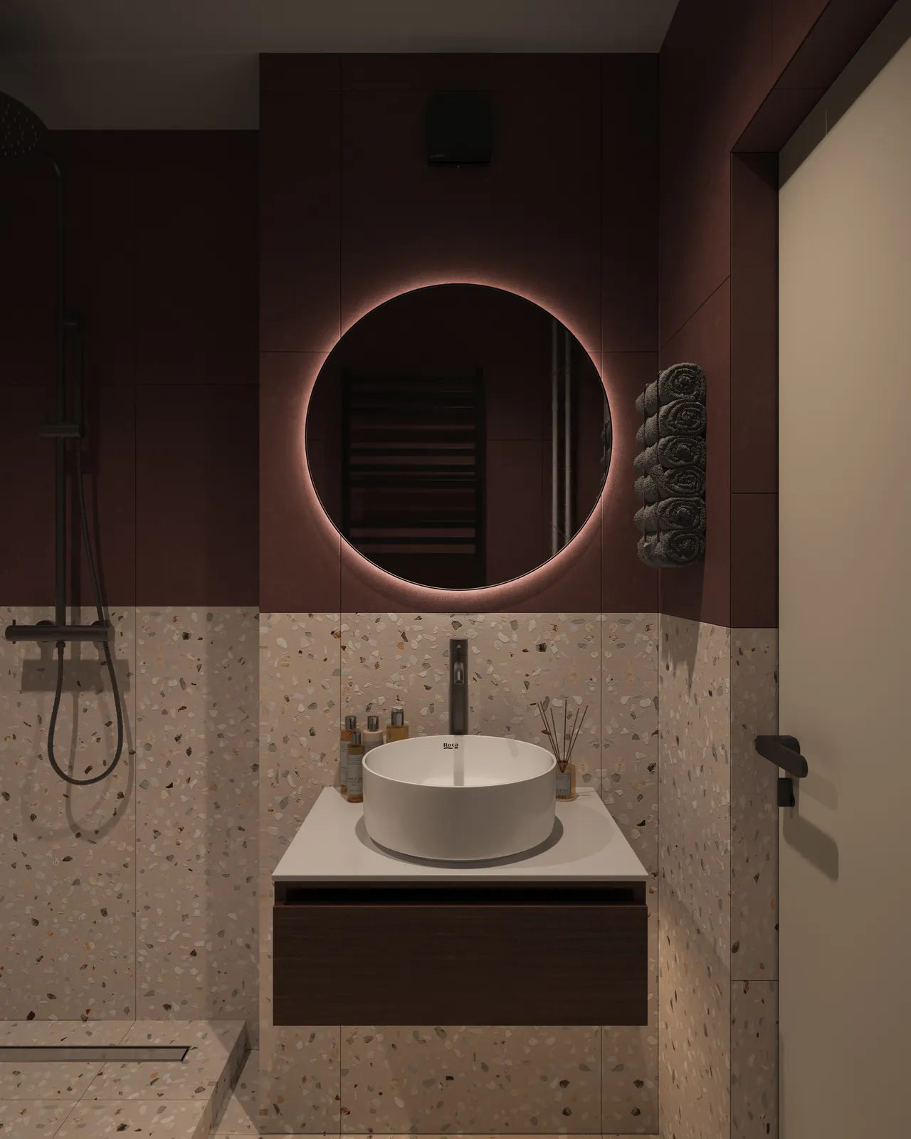 A modern bathroom with a round mirror, a circular sink on a countertop, textured walls, and a shower area in the background. The color scheme is predominantly dark with subtle lighting.