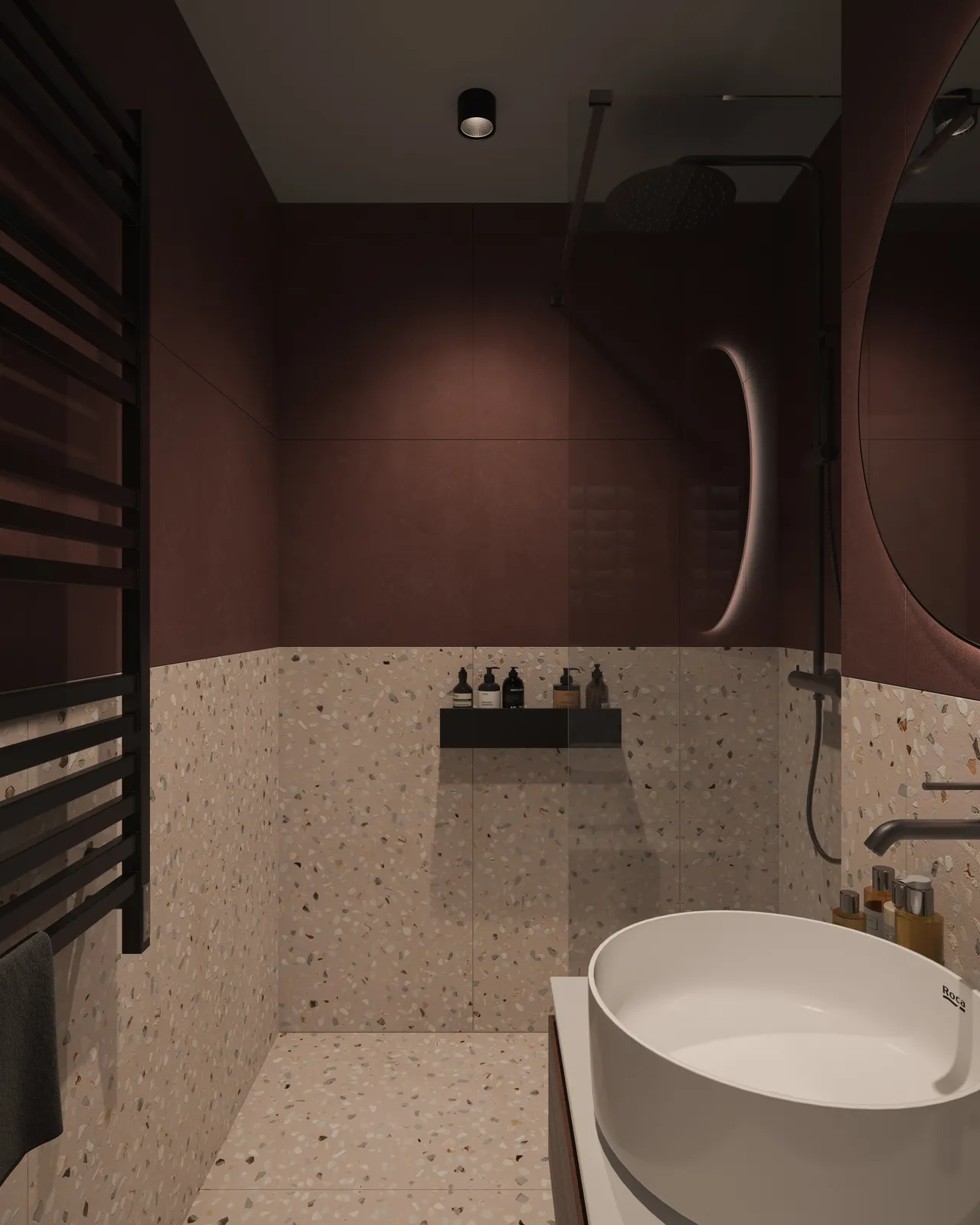 A modern bathroom featuring a walk-in shower with textured walls, a round mirror above a white sink, and decorative items on shelves. The color scheme includes dark maroon and light beige tiles.