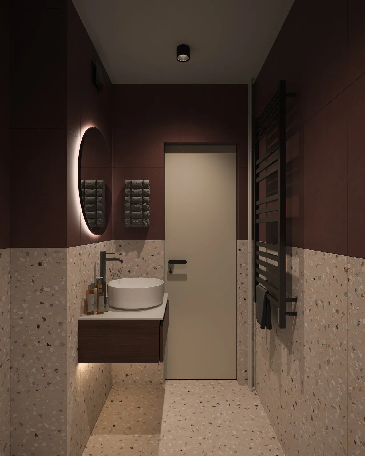 A modern bathroom with dark red walls and a light-colored tiled floor. It features a round mirror above a circular sink, a wooden vanity, and minimalist decor. A door leads to another space, and there are two wall-mounted fixtures on one side.