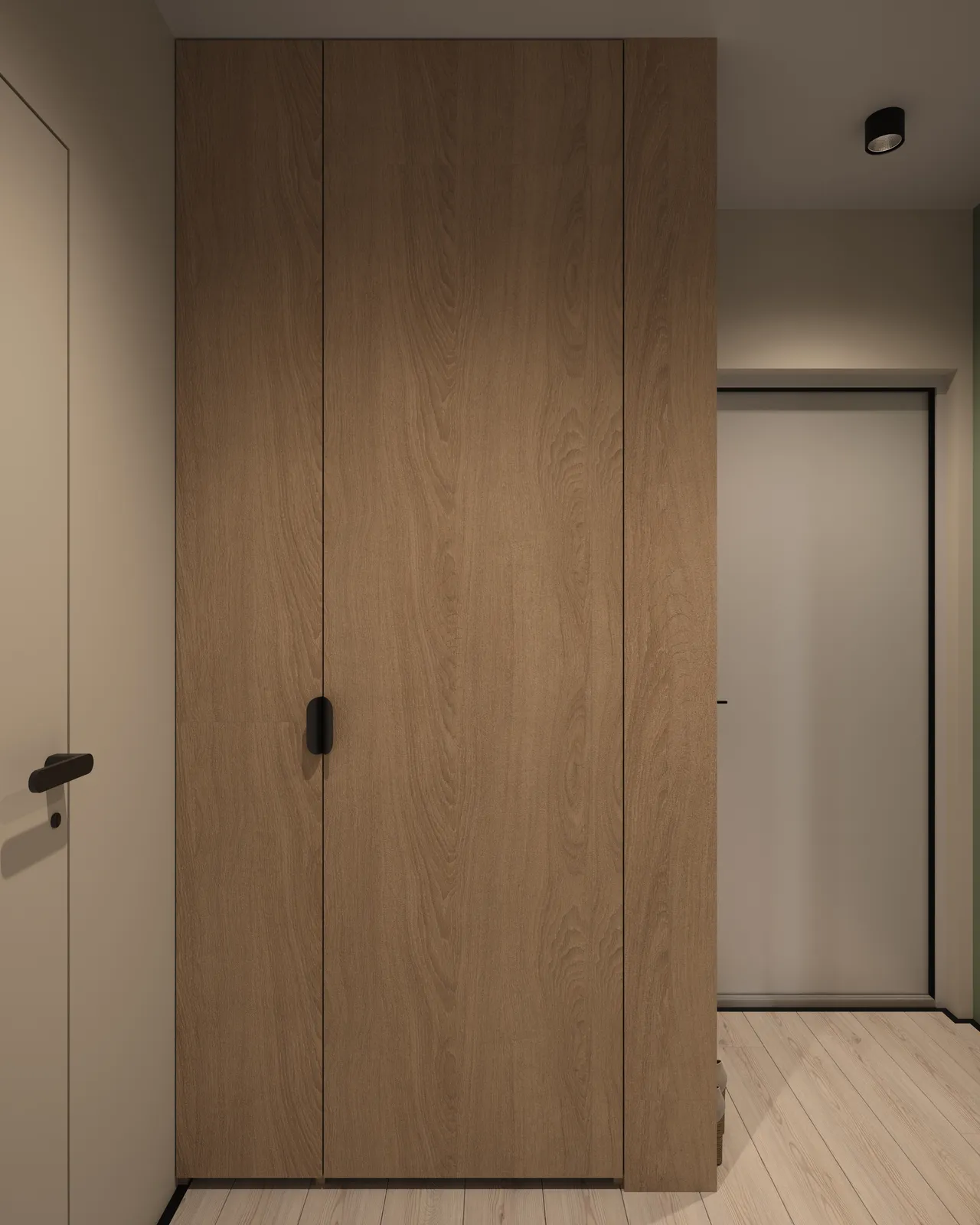 A hallway with wooden paneling, featuring a closed cabinet door and a white door in the background. The flooring is light-colored wood, and there is minimal lighting above.