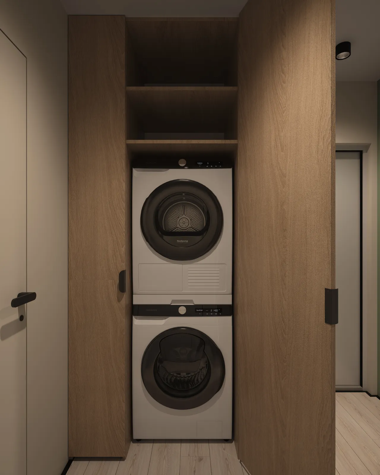 A stackable washer and dryer unit fitted into an alcove with wooden cabinet doors and shelves above.