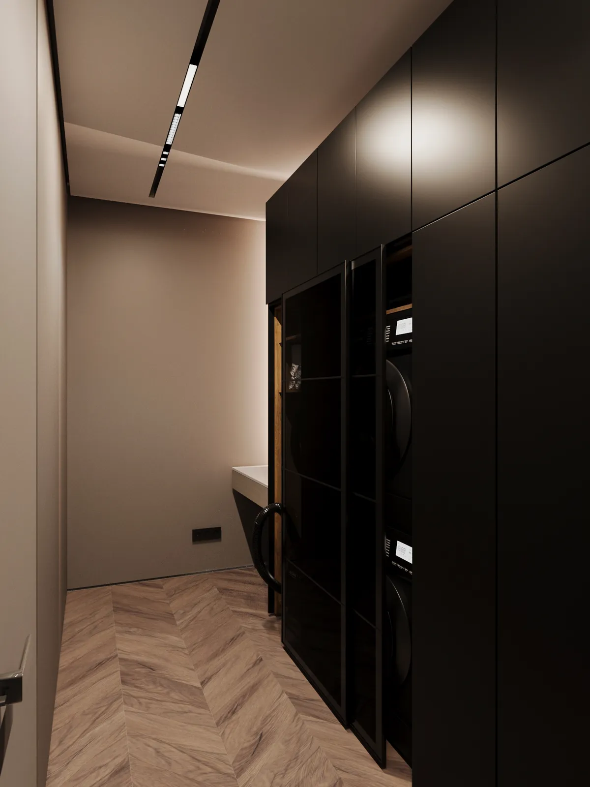 Narrow washing room featuring light beige walls, a light wood herringbone floor, and floor-to-ceiling matte black built-in cabinetry concealing laundry appliances.