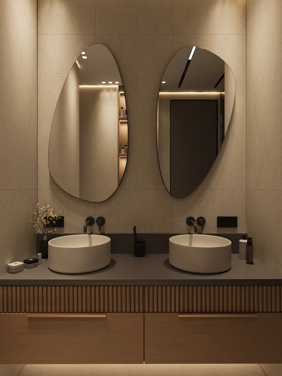 Modern bathroom with two oval mirrors and vessel sinks on a sleek gray countertop. Minimalist decor with soft lighting creates a calm ambiance.