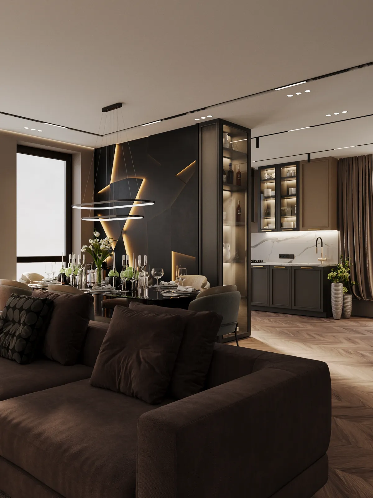 Luxurious modern living space featuring a dark brown sectional sofa in the foreground, a formal dining area, and a sleek dark kitchen nook with illuminated glass cabinetry.