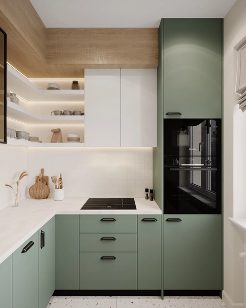 Modern kitchen with sage green lower cabinets, white upper cabinets, and wooden accents. Sleek black appliances, open shelves, and neutral decor create a cozy, minimalist feel.
