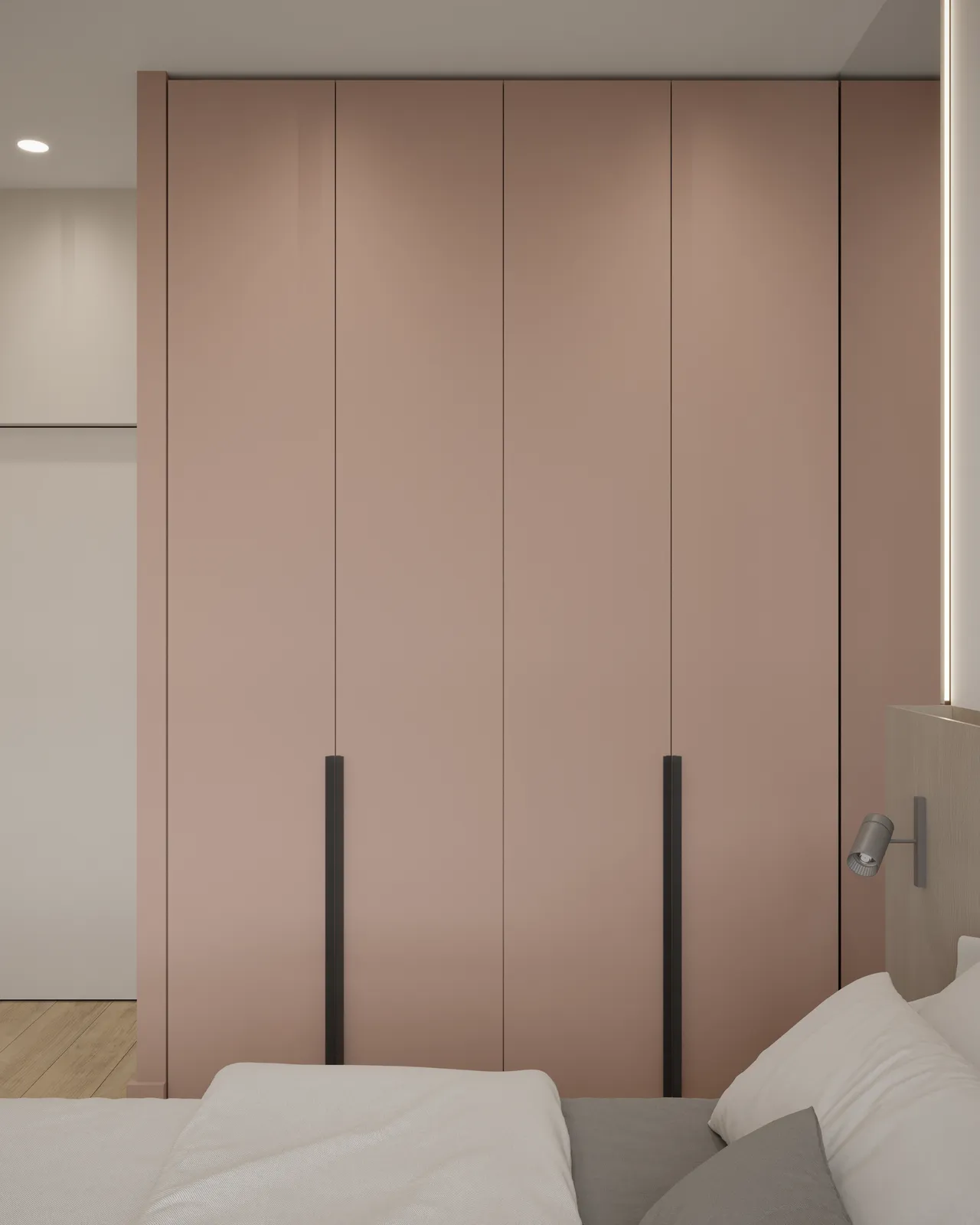 A modern bedroom featuring a pink wardrobe with slim black handles, and a neatly made bed with white bedding.