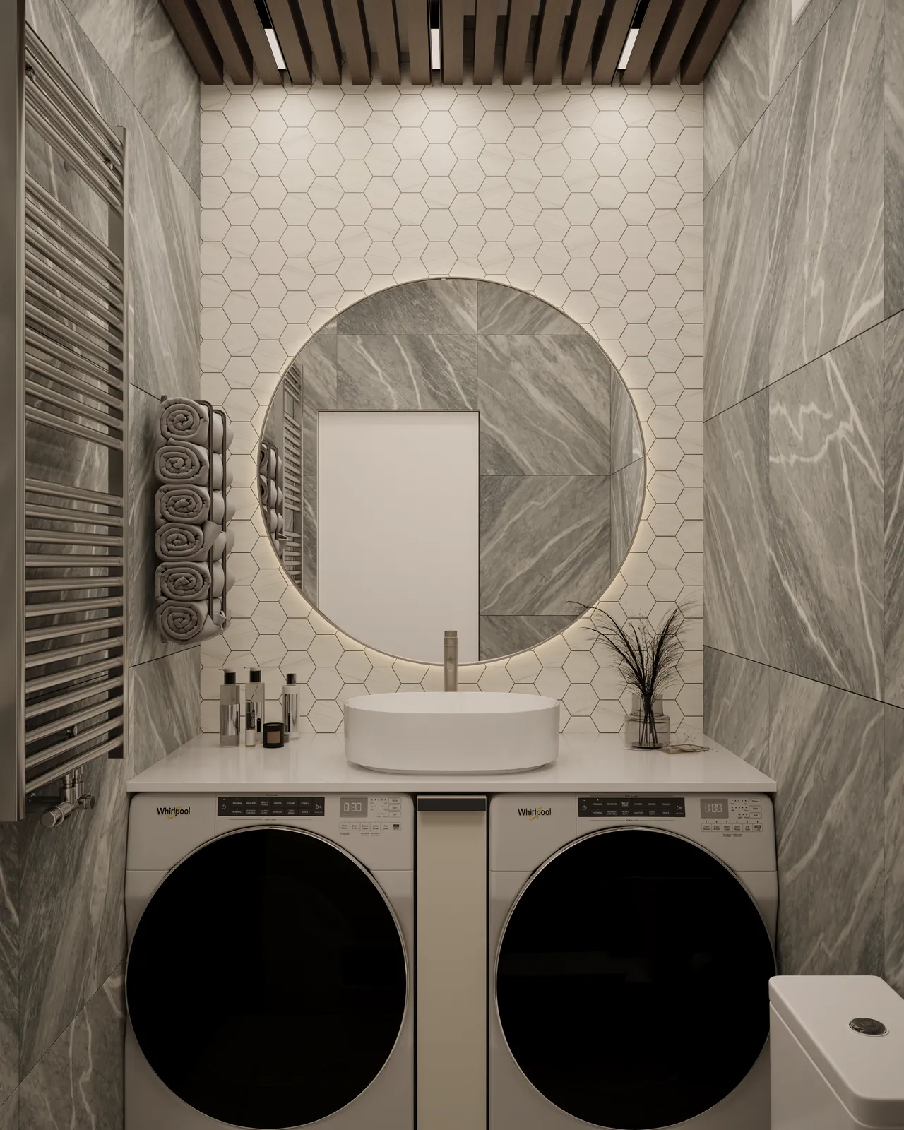 A modern bathroom featuring a circular mirror above a stylish sink, with a countertop. Below the sink, there are stacked laundry machines. The walls are covered with hexagonal tiles, and there is a towel rack on the side along with decorative items like plants and bottles. The ceiling has wooden slats with recessed lighting.