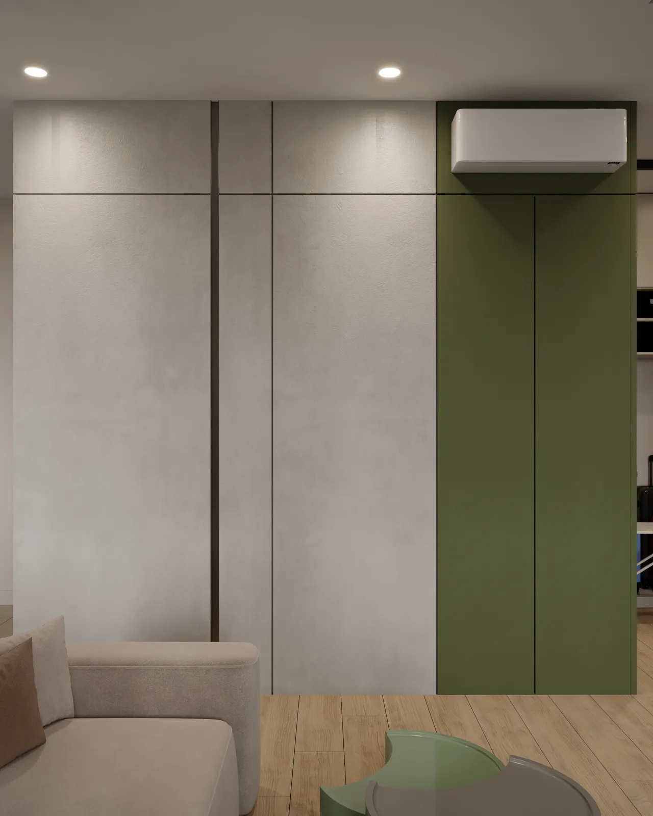 Minimalist room with a modern air conditioner on a green accent wall. Neutral-toned sectional sofa and wooden floor create a cozy, elegant ambiance.