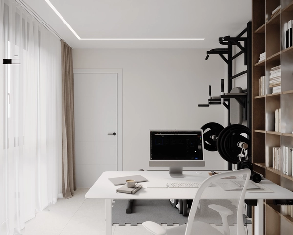 A workspace with a white desk, a monitor, an ergonomic chair with a mesh back, fitness equipment mounted on the wall and natural light filtered through sheer curtains.