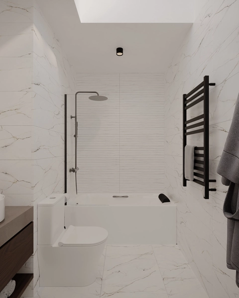 A white marble bathroom, with a straight bathtub, a rain shower fitting, a glass screen, a compact toilet, a black towel radiator and natural light from above.