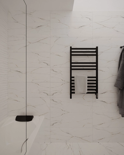 A detail of the white marble bathroom with golden veining, with a black towel radiator, a glass screen and the edge of the bathtub.