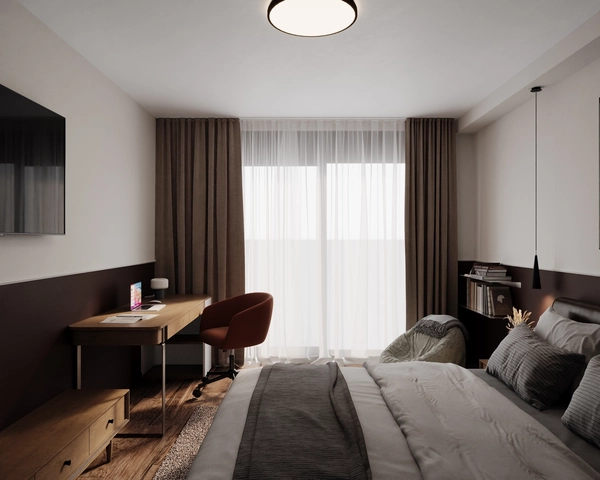 An overall view of the bedroom, with a double bed, a wooden desk with a brick-colored upholstered chair, a television on the wall and a large window with sheer curtains.